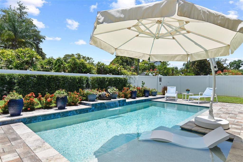 Mature landscaping and vinyl fence create a quiet space to relax