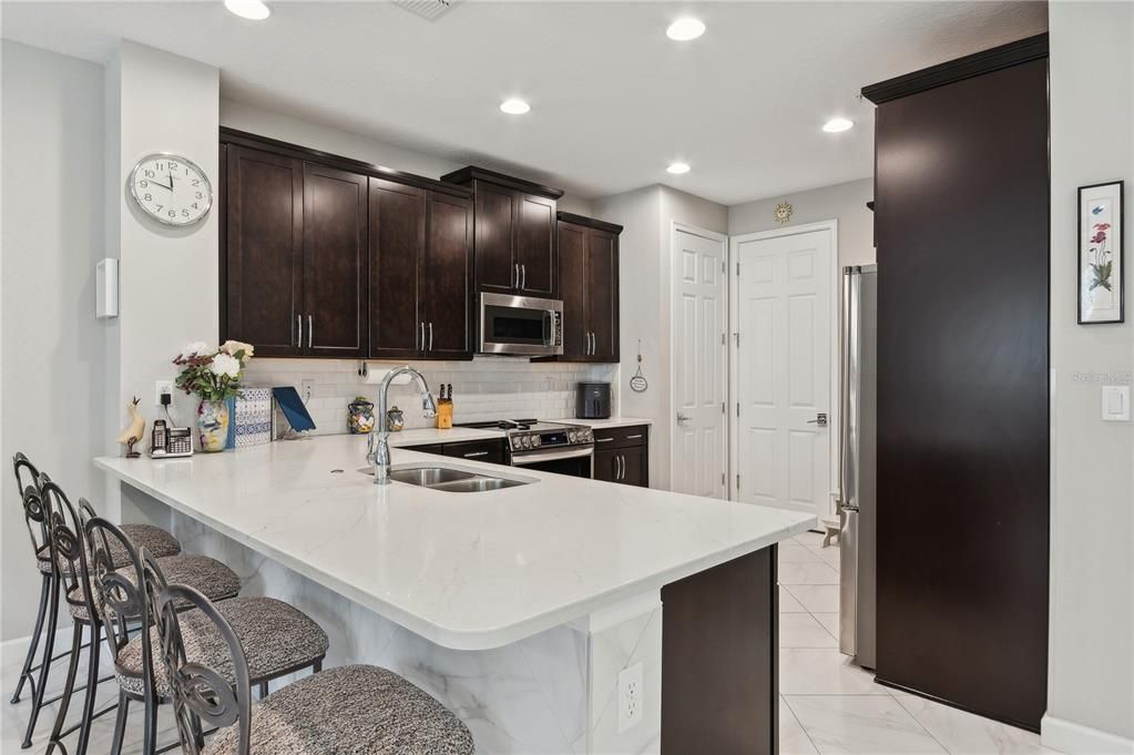 Kitchen with breakfast bar, quartz counter tops, solid wood espresso cabinets.