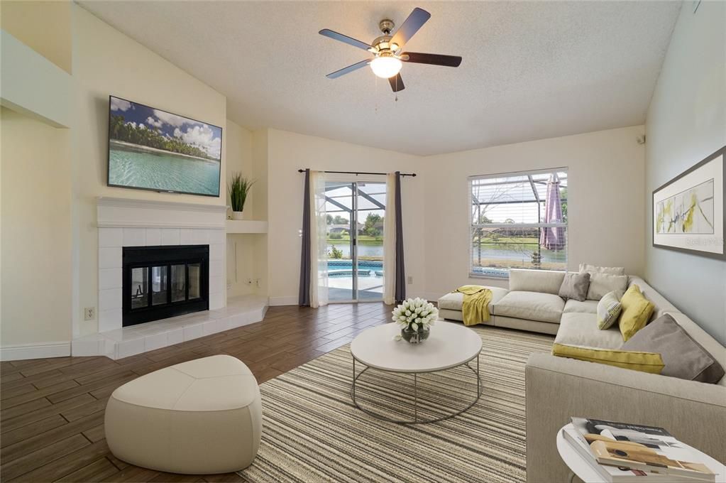 spacious living area with fireplace that has easy access to the glass sliding door lanai leading to the pool