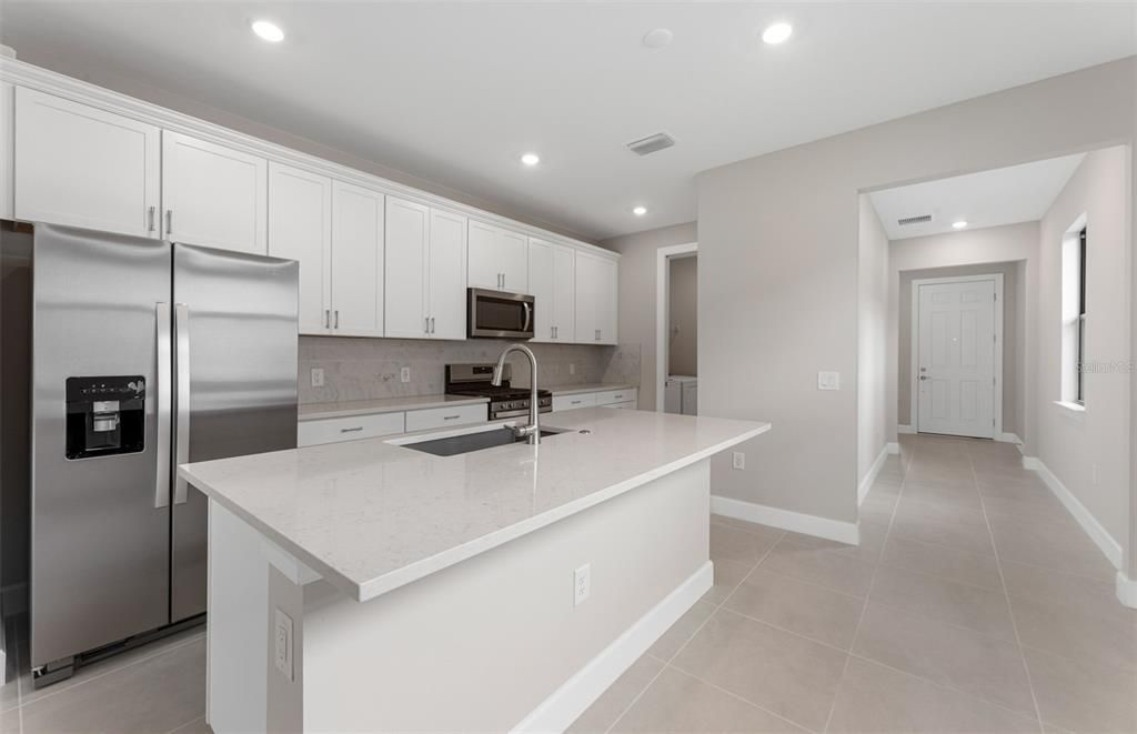 Kitchen island, stainless steel appliances, stylish backsplash!