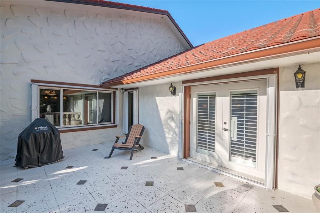 Enjoy your morning coffee or evening meals on this elegant patio, featuring charming architectural details and surrounded by lush foliage.