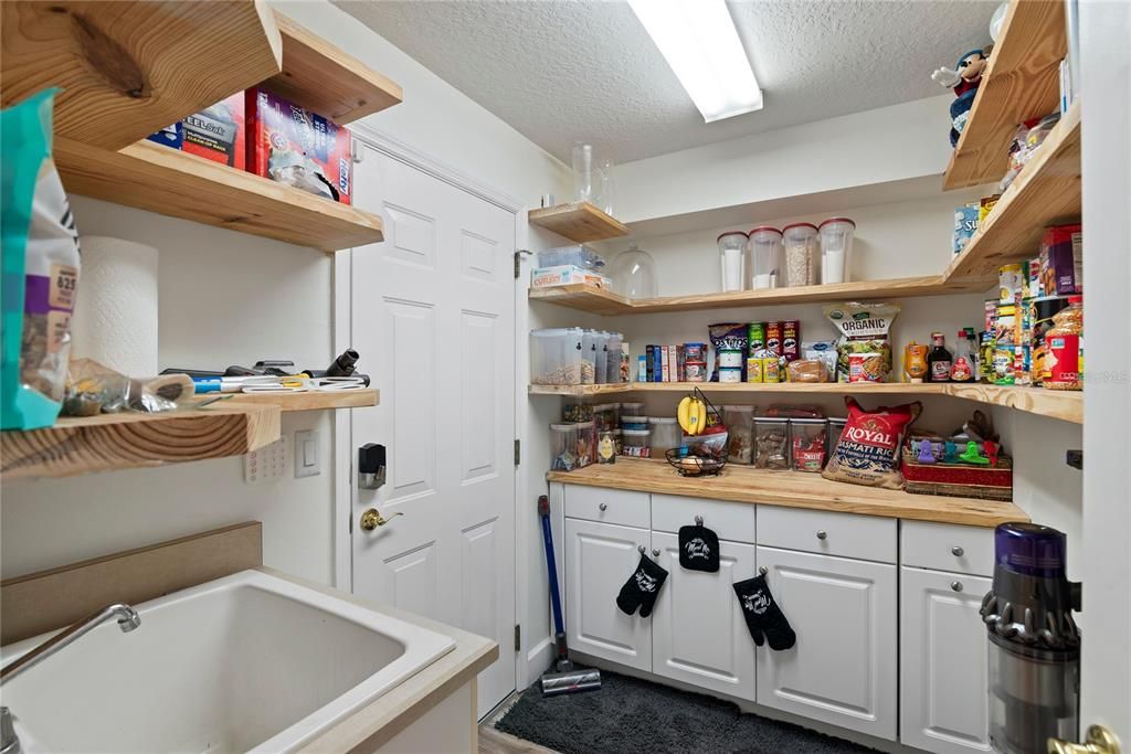 Custom added walk in pantry with butcher block countertops, shelving and cabinets to exceed your storage needs