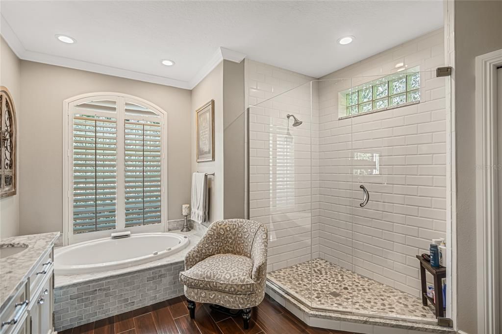 Primary bath with seamless shower door and stone floor