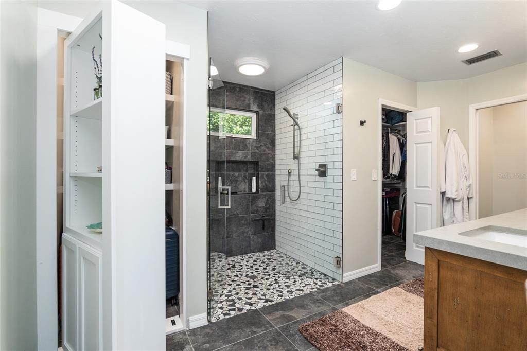 Owners bath with built in shelves and hidden storage