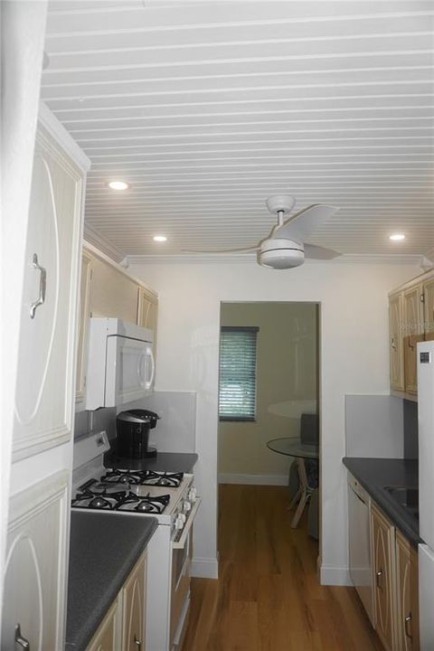 The kitchen features a beadboard ceiling with lighting & ceiling fan ...