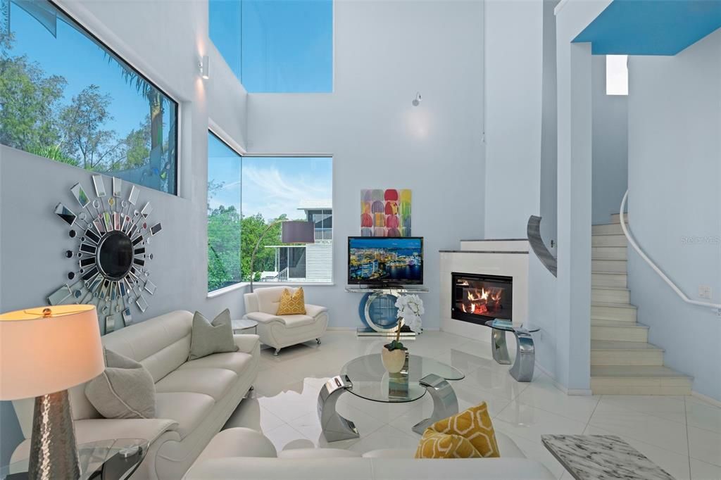 The 2-story living room boasts a soaring ceiling and electric fireplace that creates a relaxing ambiance.