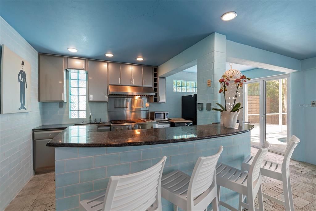 The first level features an indoor/outdoor swimming pool and spa, screened-in lounge area and full outdoor kitchen with stainless appliances and gas range making it the perfect place for family fun and entertaining.