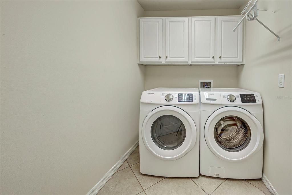 The laundry room has cabinets and shelving.  Room to hang your delicates clothing to dry.