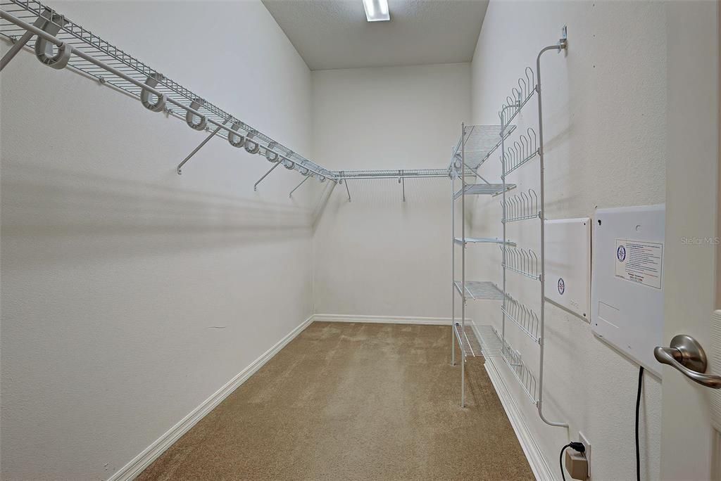 Primary bedroom walk in closet, plenty of room to hange closes, store items on shelves and there is even a shoe holder.