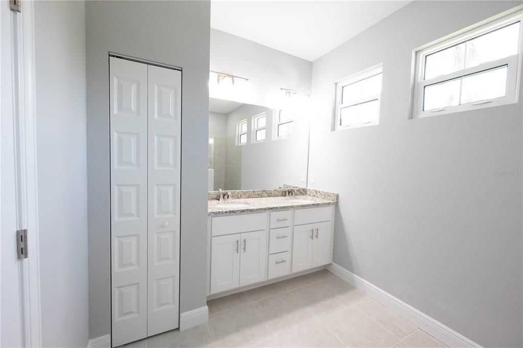 Spacious Primary Bathroom with dual sinks and large vanity with large linen closet