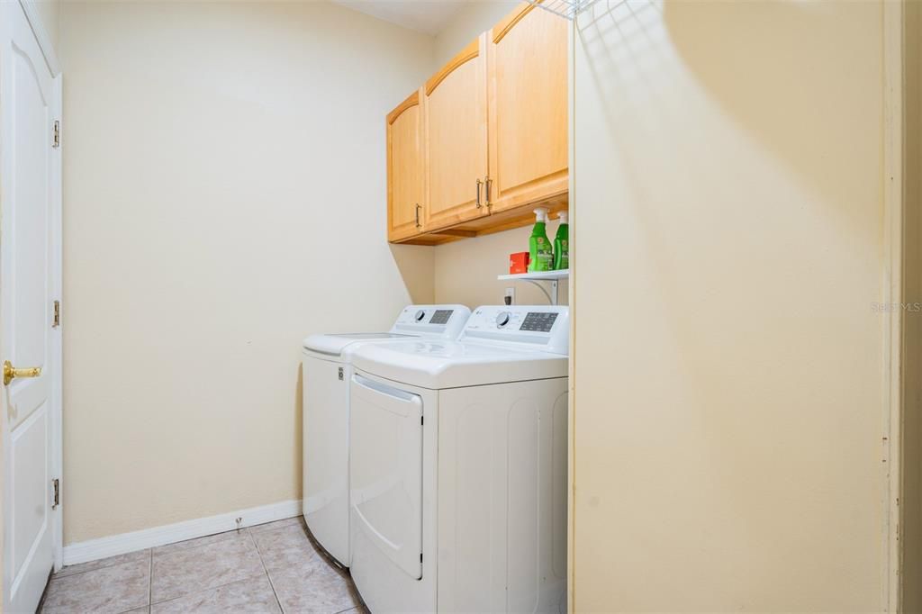 Interior laundry room with storage cabinets above!