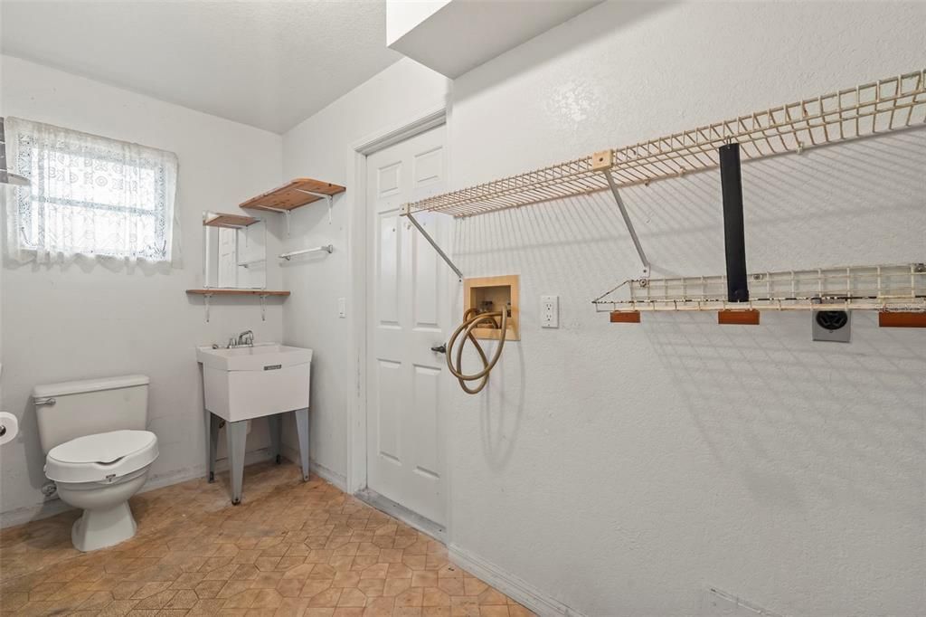 Laundry room with hookups and utility sink and 3rd toilet. Access to Garage