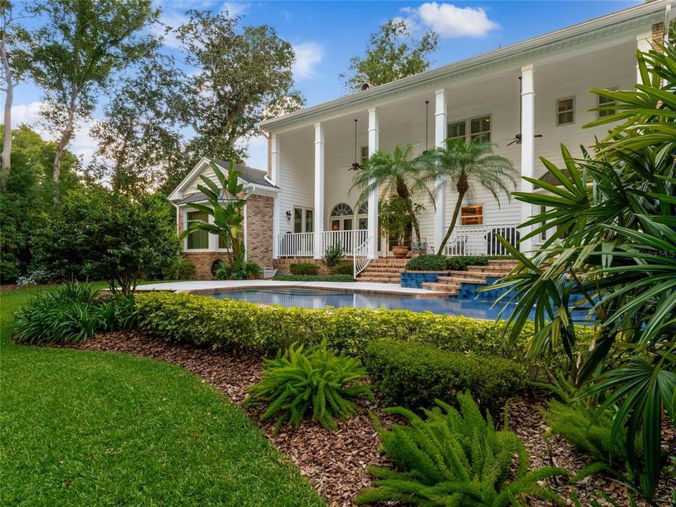 Back of the home, expansive covered porch and pool area.