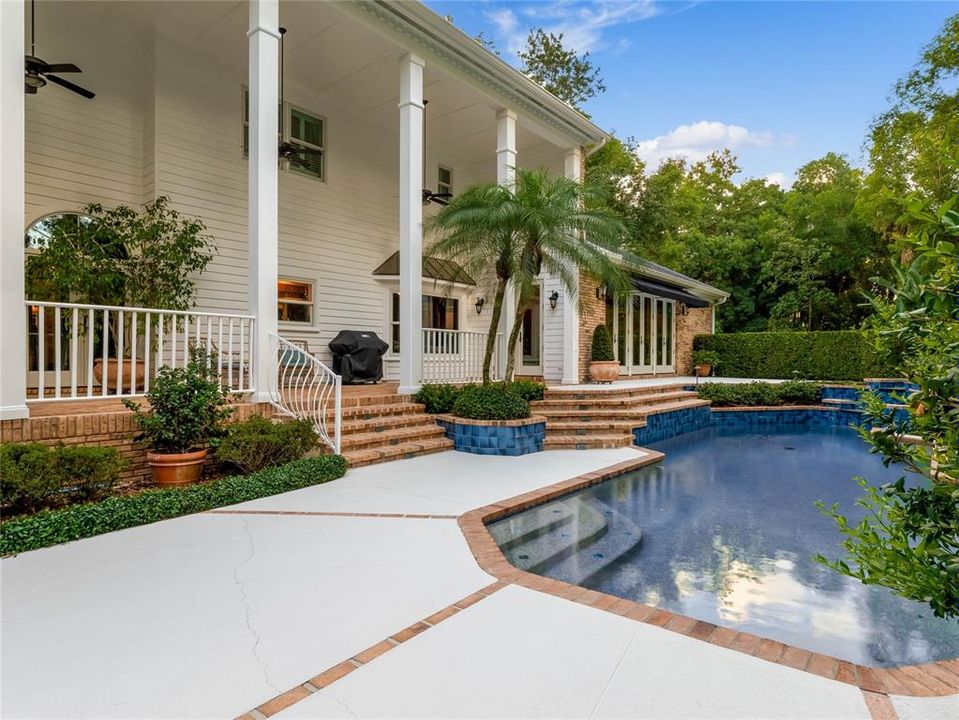 Back of the home, expansive covered porch and pool area.