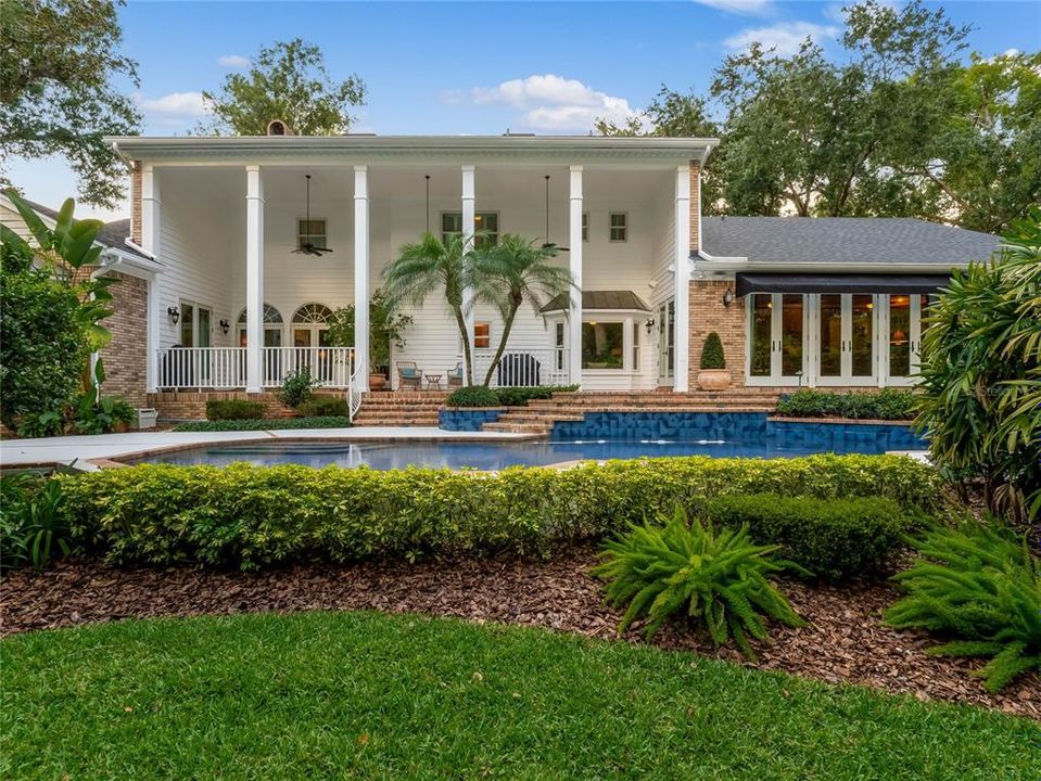 Back of the home, expansive covered porch and pool area.