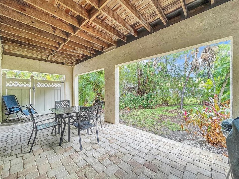 Private back yard just beyond the paver patio.  Gate to pool area shown to left.