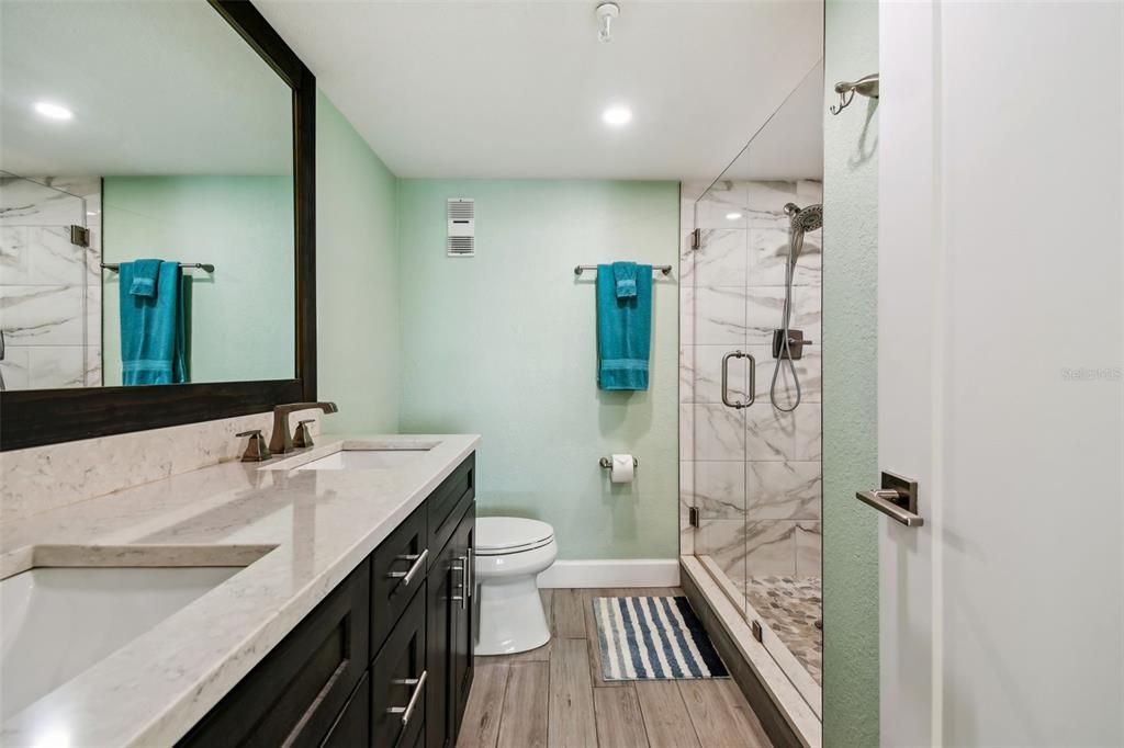 The newly renovated bathroom is spacious and features dual sinks and large walk-in shower