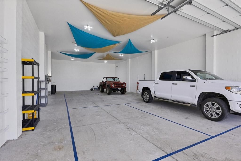 Spacious 30x60 detached garage with oversized overhead doors, screens, and pickleball court