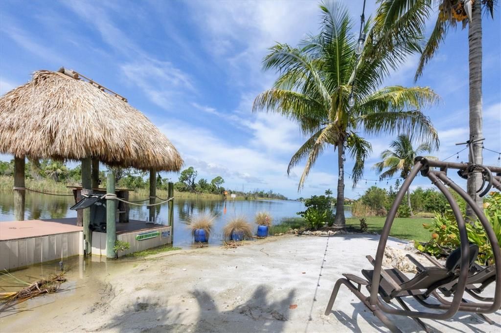 Secluded retreat with soft sand beaches, spacious dock with covered boat lift, and tiki bar