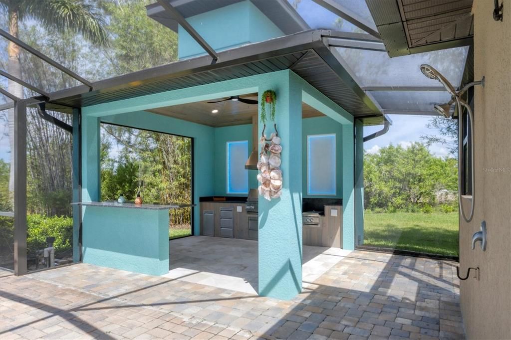 Expansive 14x14 outdoor kitchen with grill, LED lighting, and dedicated steaming station