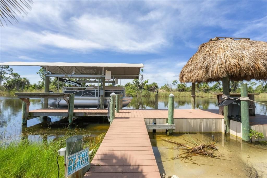 Secluded retreat with soft sand beaches, spacious dock with covered boat lift, and tiki bar