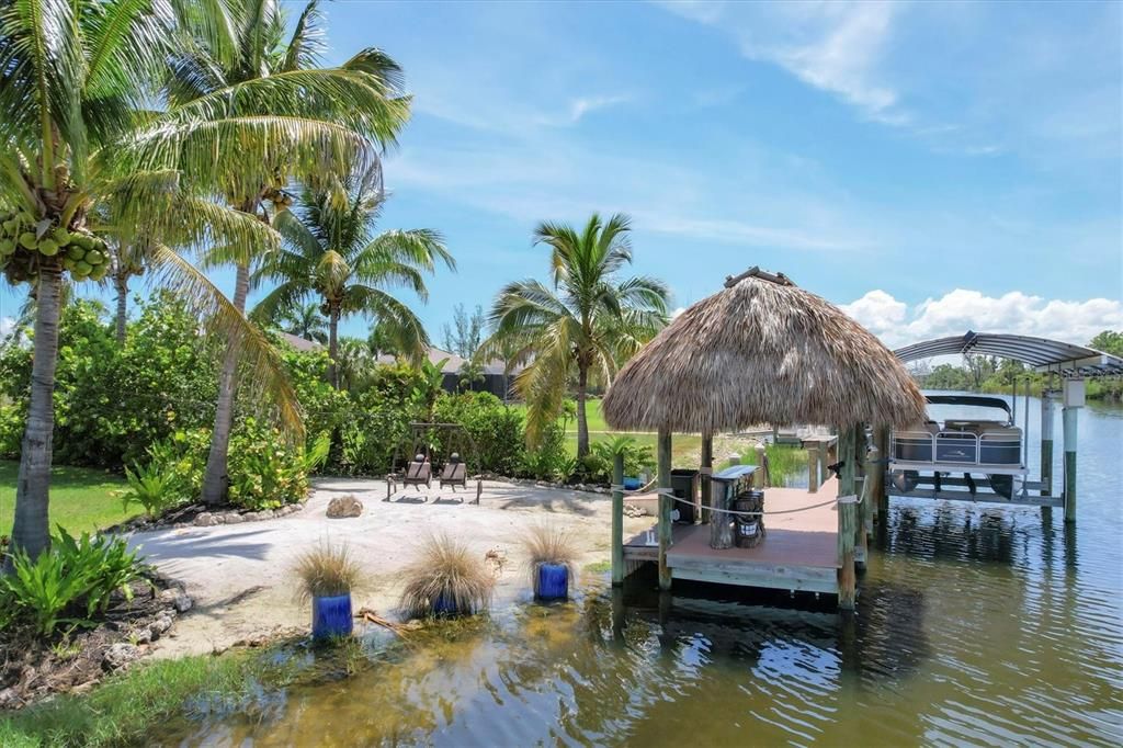 Secluded retreat with soft sand beaches, spacious dock with covered boat lift, and tiki bar