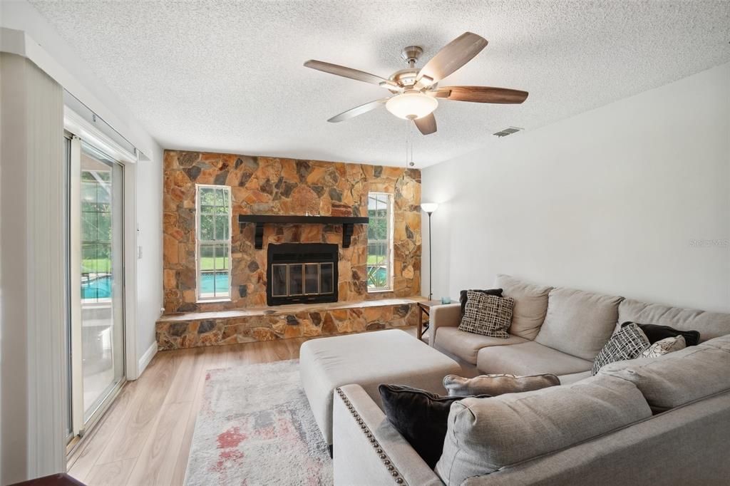 Family room with a fireplace overlooking patio and pool