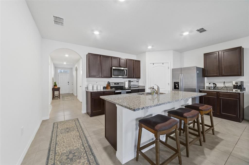 Open concept kitchen features stainless steel appliances.