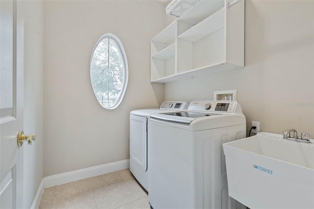 Dedicated laundry room with sink and a window