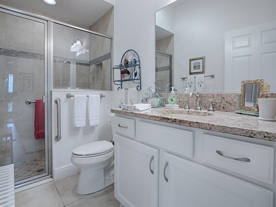 BATHROOM #2 ON THE GUEST WING SIDE IS LOVELY WITH A FULLY TILED STEP IN SHOWER & GRANITE COUNTERTOP