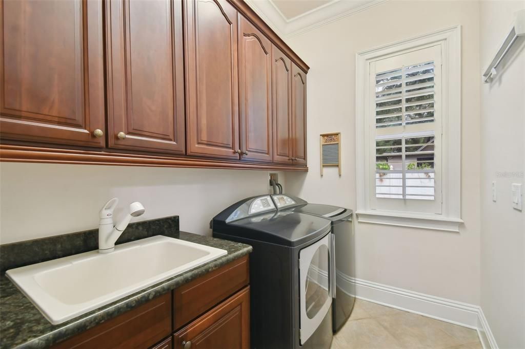 Laundry room with sink and built-in cabinets