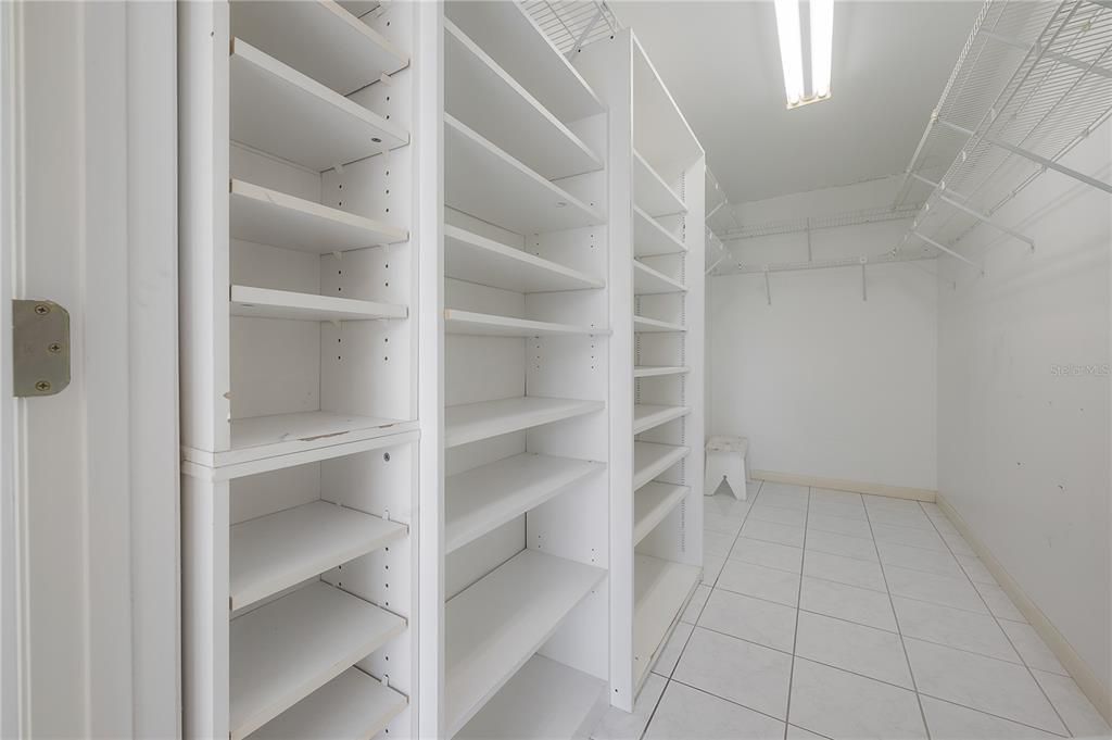 Primary Suite bathroom with linen closet, large vanity, and step-in shower