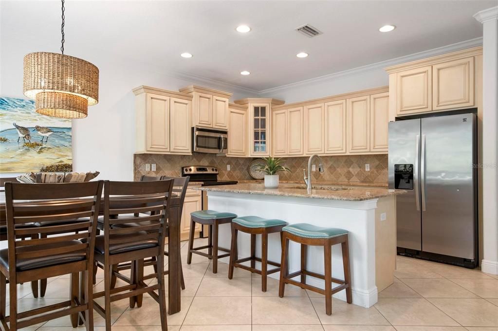 Open concept kitchen and dining with island and stainless appliances