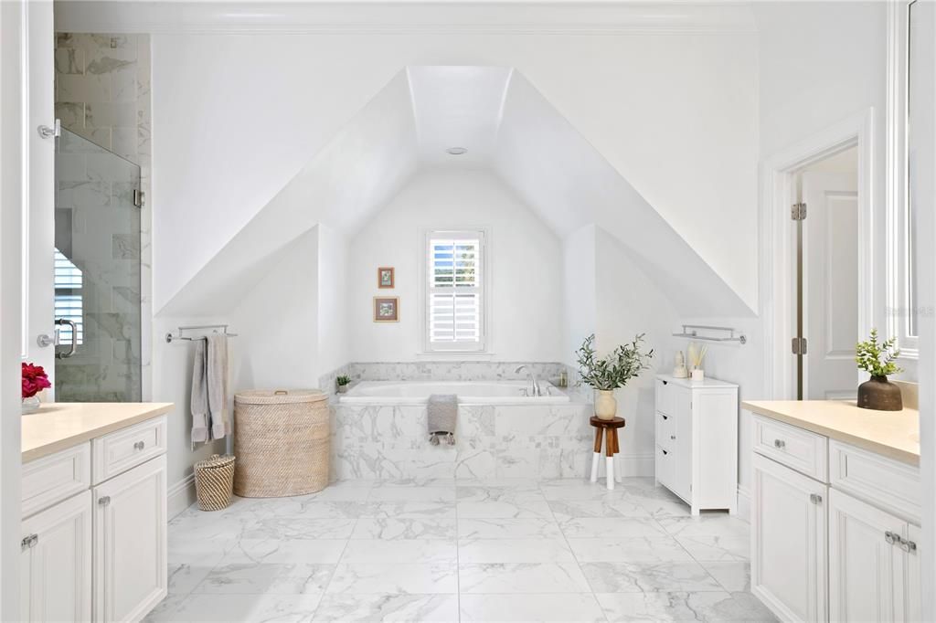 The primary bath is beautifully appointed with vaulted ceiling details adding wonderful architectural flare to the space, and is nicely appointed with split vanities, oversized walk-in shower, and a free-standing tub.