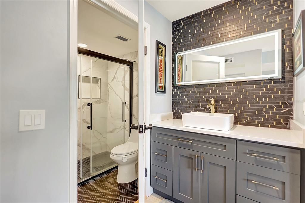 Explore the convenience and style of this condo's second bathroom, complete with a built-in cabinet offering ample storage space.