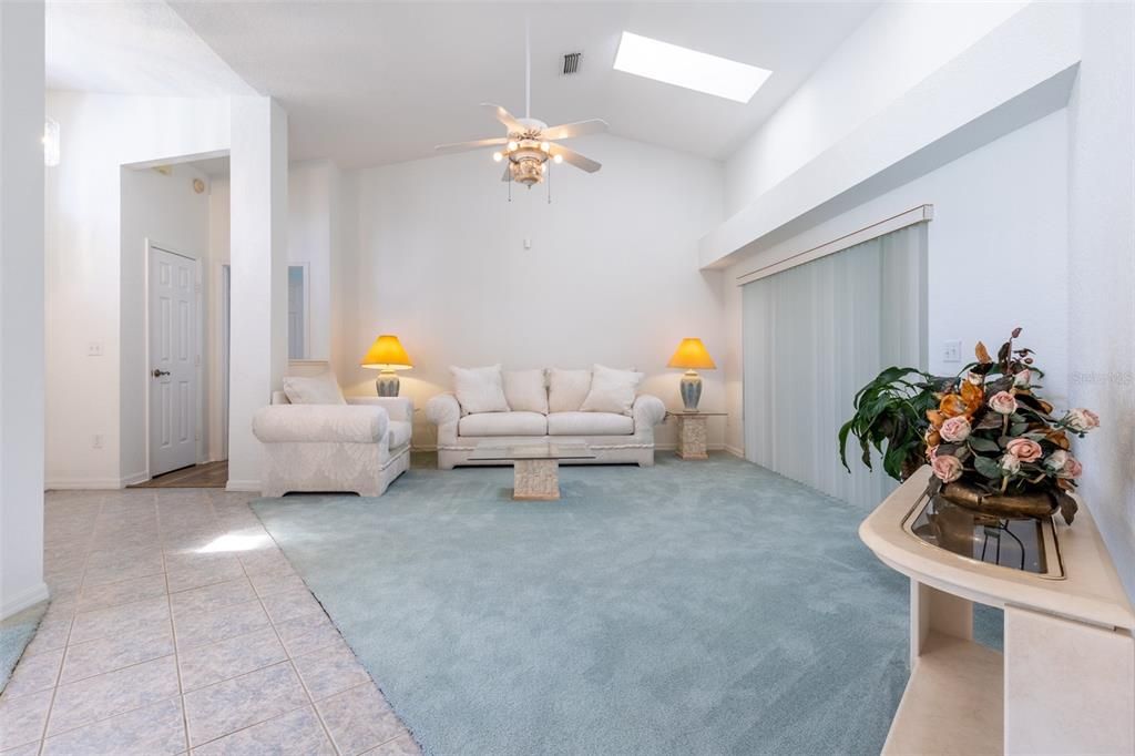 the open Living Room, with high ceiling Alcove and easy access to the Lanai (thru sliding doors, right) for gracious entertaining.