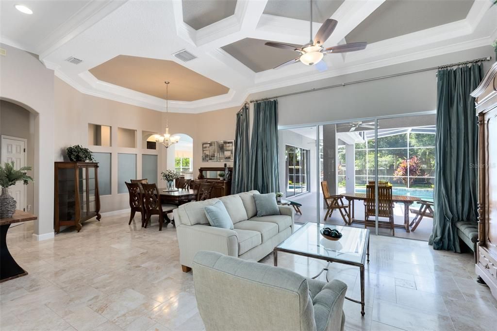 Living room with tray ceilings and large sliders to outside