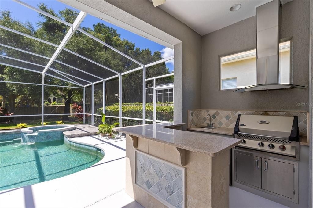 Outdoor kitchen. Granite bar, built-in grill, sink and fridge!