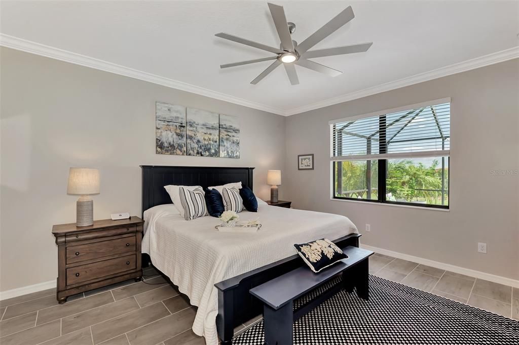 The master bedroom hosts a kind size bed and nightstands, bench and dresser with ample room.