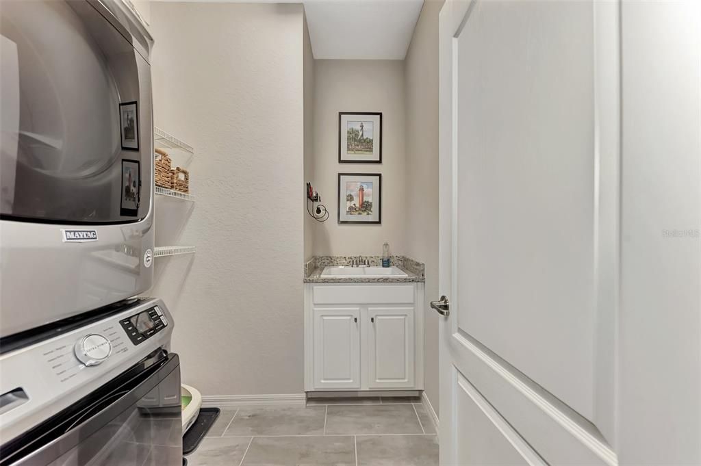 The laundry room was reconfigured to house a full size washer/dryer and storage cabinet and sink.  There is hanging room next to the washer/dryer also.