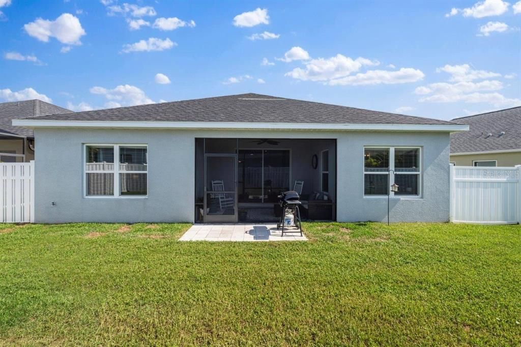 Fenced-in Back Yard with an extended paver patio.