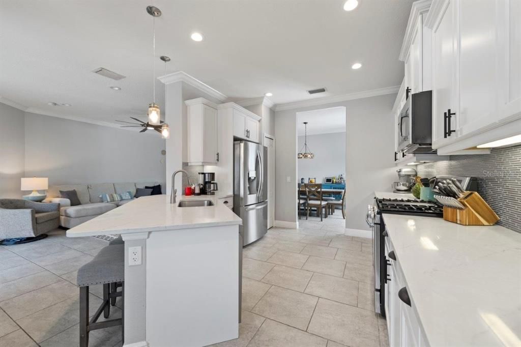 Spacious kitchen featuring ample cabinetry, stainless steel appliances, and a stunning backsplash.