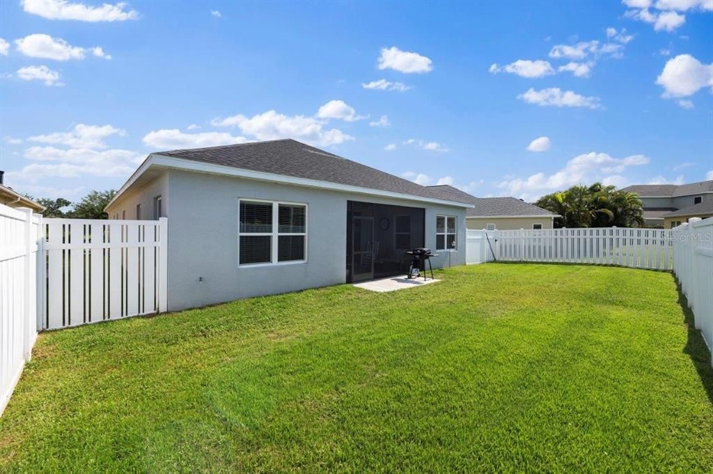 Fenced-in Back Yard with an extended paver patio.