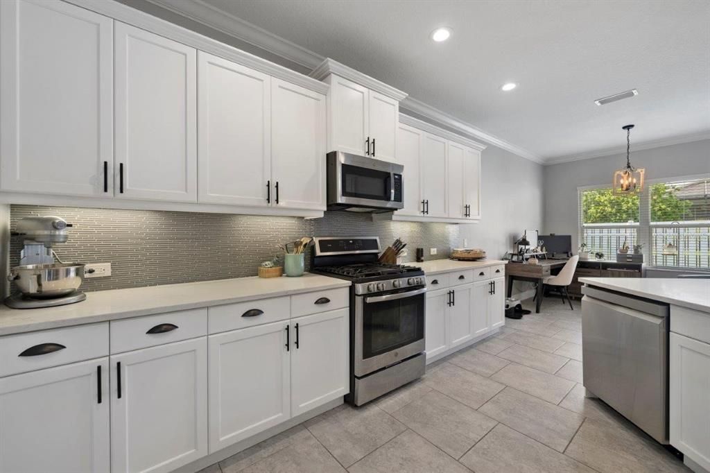 Spacious kitchen featuring ample cabinetry, stainless steel appliances, and a stunning backsplash.