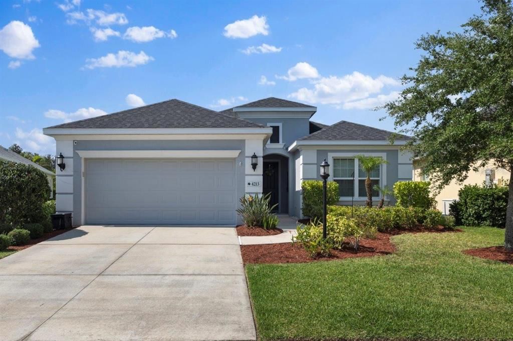 Front Elevation showing the lush landscaping, and front entryway.