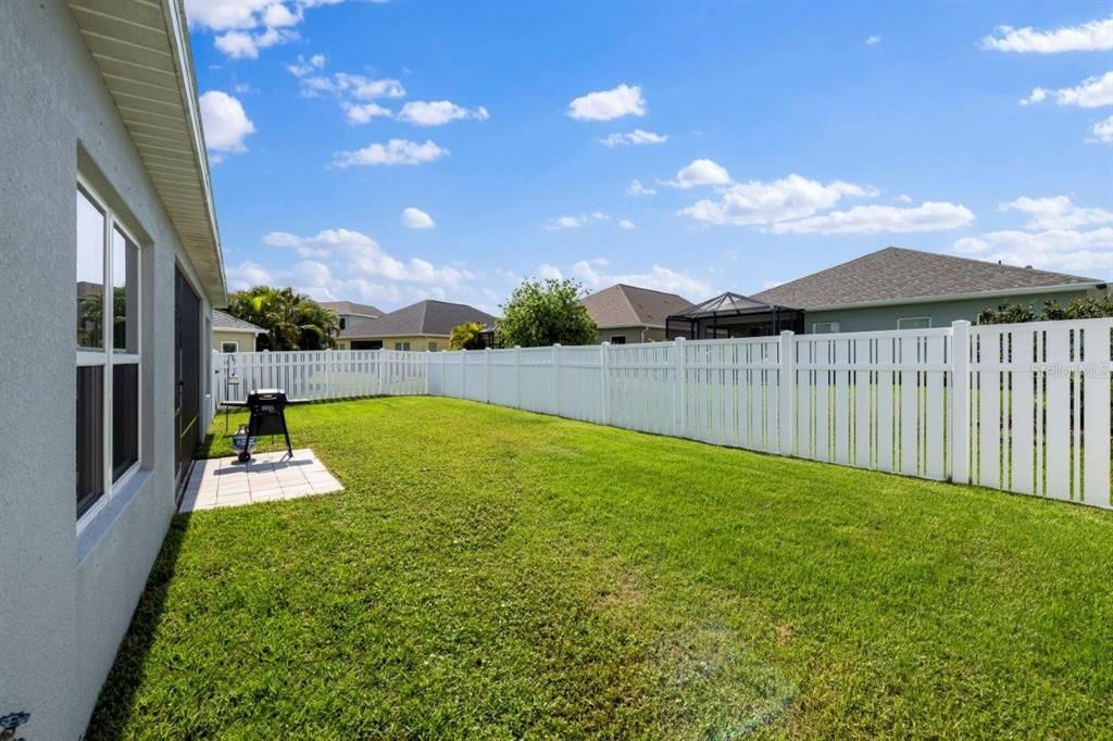 Fenced-in Back Yard with an extended paver patio.