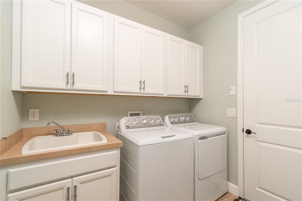 Laundry room off garage and kitchen with sink