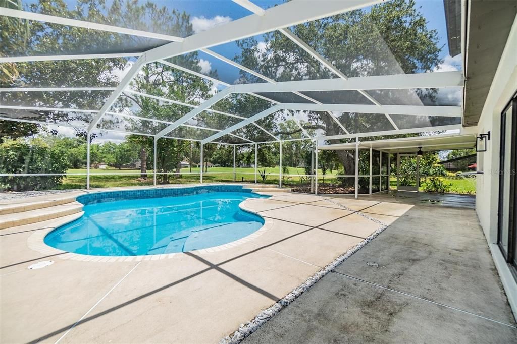 Screened-in Pool view from family room slider and looking toward covered patio