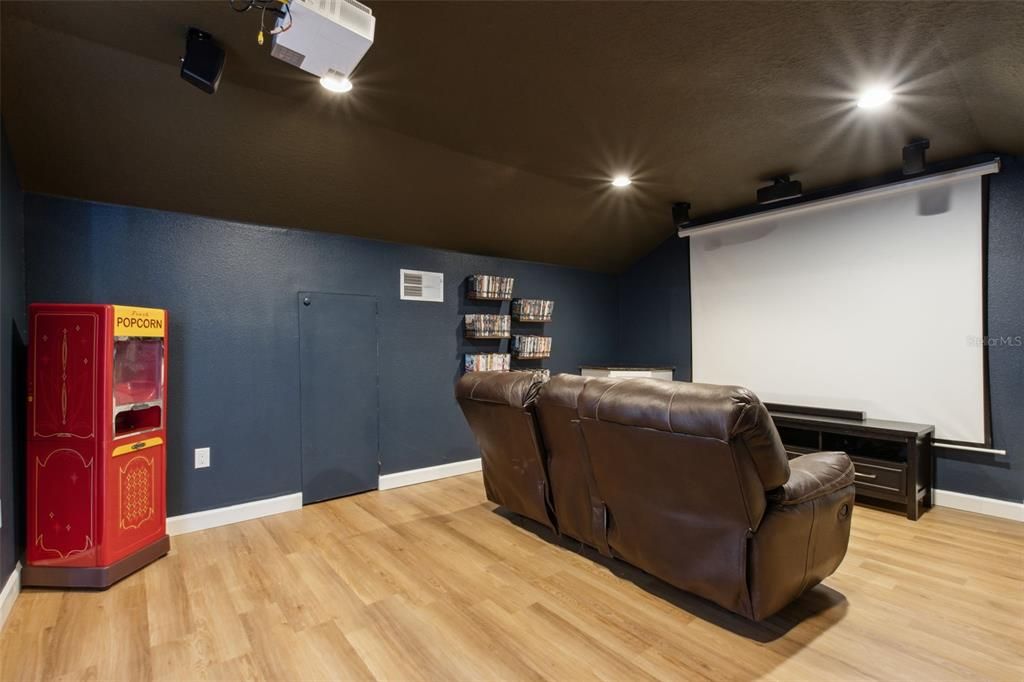 Theatre room featuring projector and screen