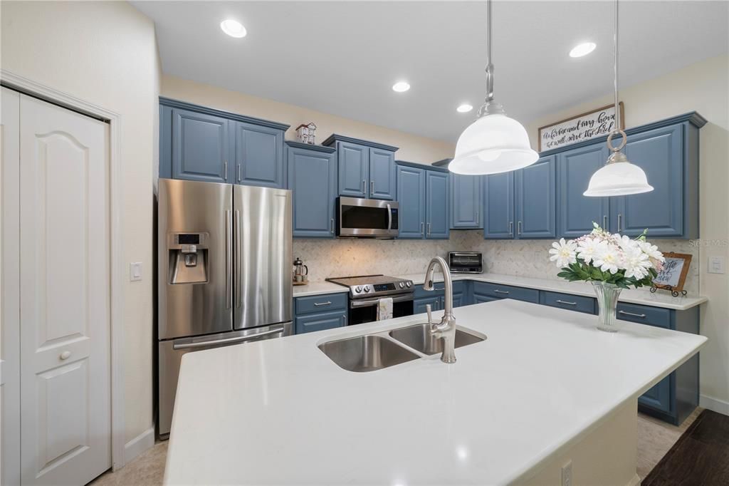 Updated kitchen features a prep station with breakfast bar and quartz countertops